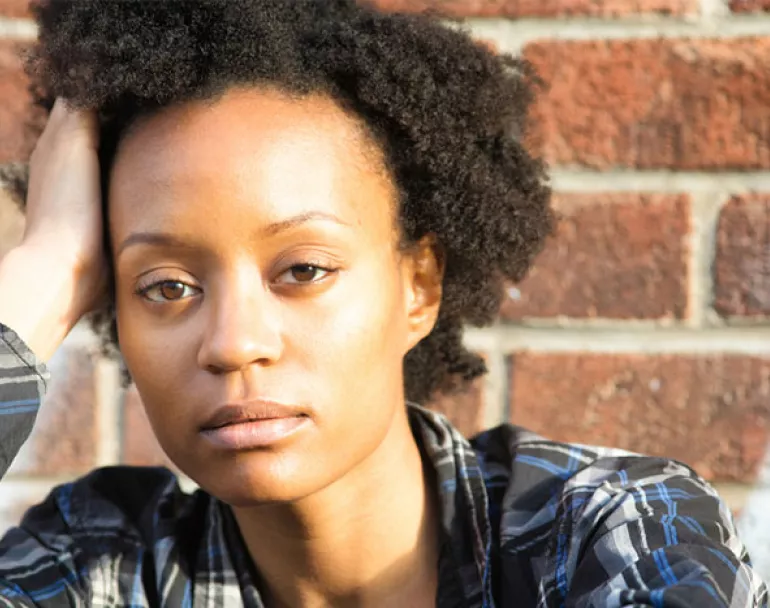 Former homeless youth outside in front of brick wall | Covenant House
