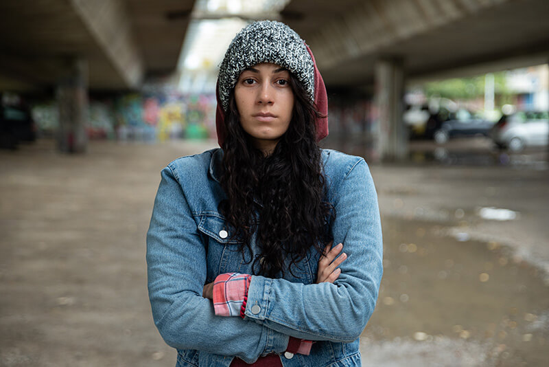 Homeless young woman standing alone in the cold