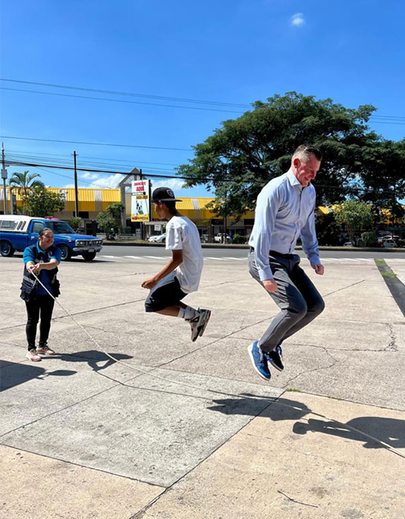 Covenant House Honduras children, staff, and CEO Bill Bedrossian playing with jump rope