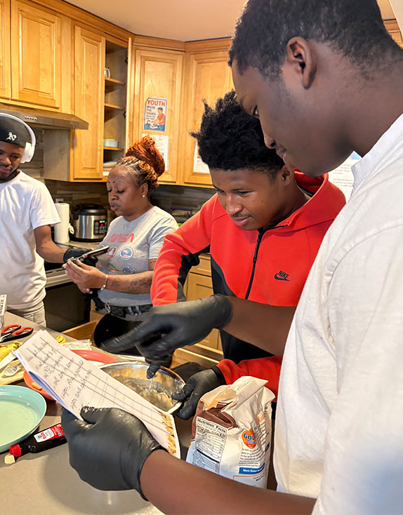 Covenant House youth cooking holiday meals in kitchen