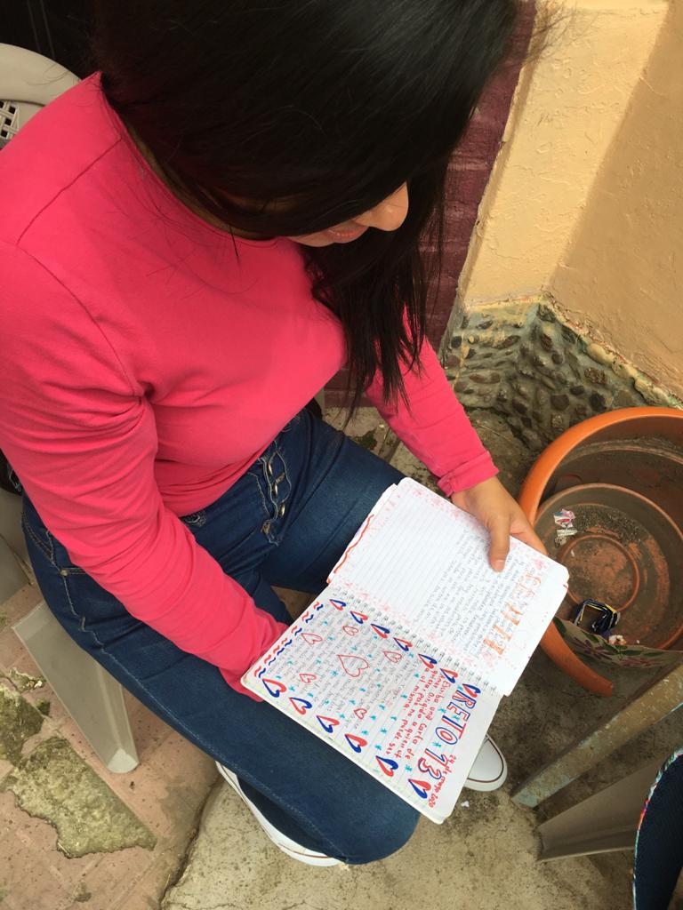 A close-up God's-eye view of a resident of Covenant House Honduras going over her journal.