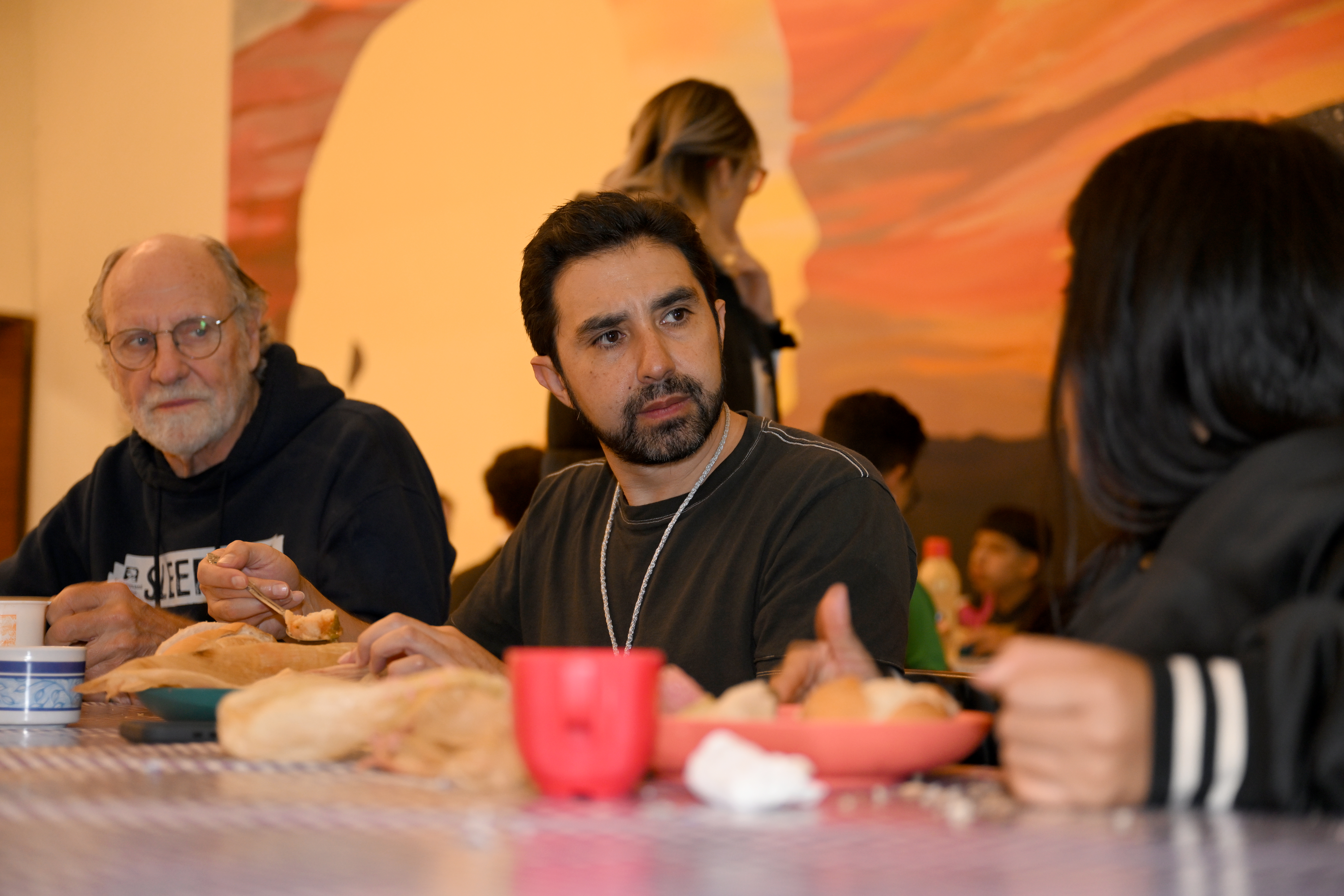 Ramiro Menchaca (center) and Jon Corzine listen over a light dinner to a girl at Covenant House Mexico.