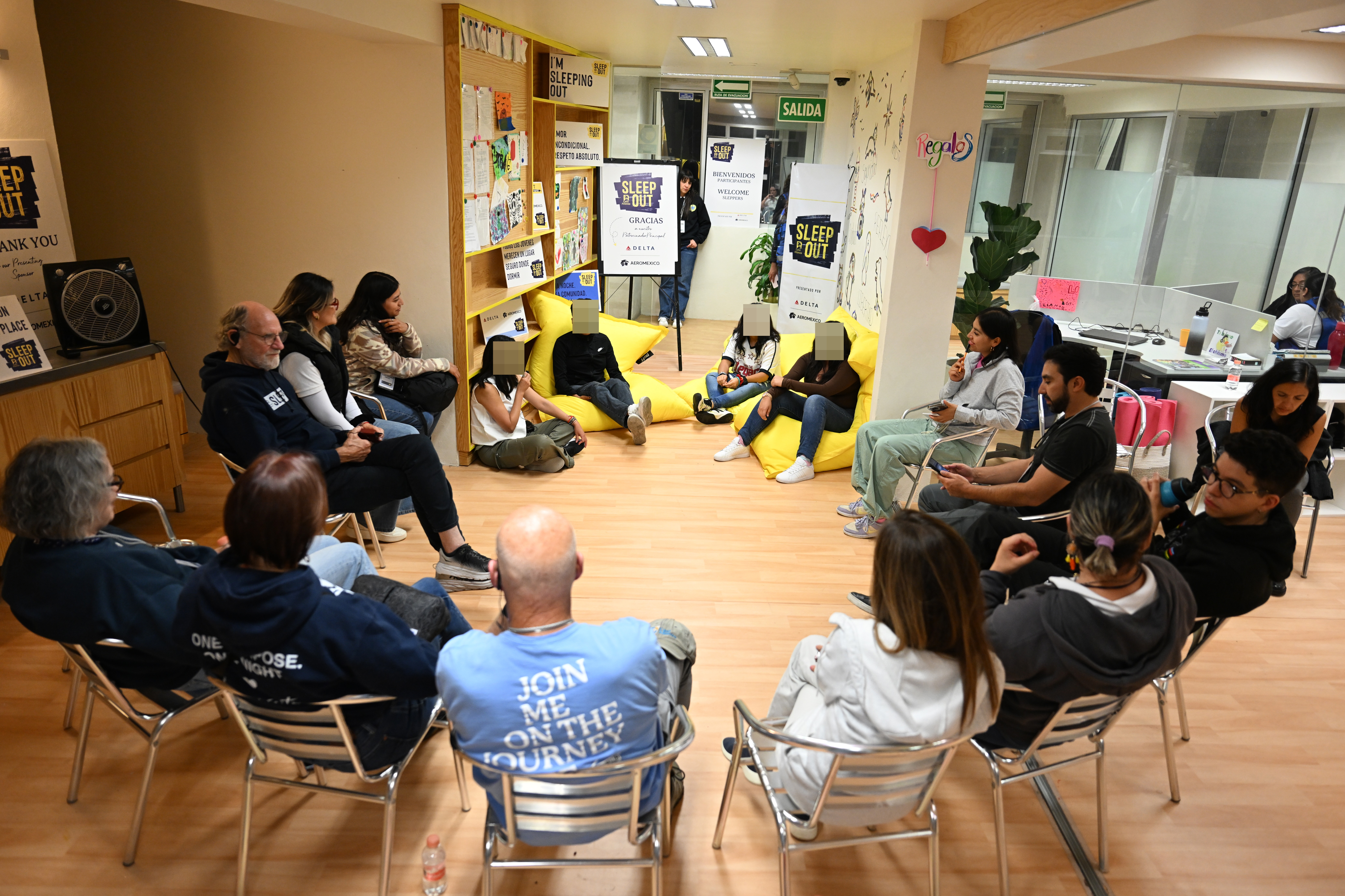 Sleep Out participants at Covenant House Mexico listen in a circle to youth sharing their stories.