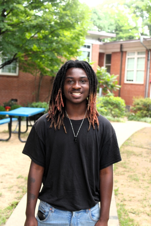 Anyaris, a resident of Covenant House Georgia, smiles as he poses outside of transitional housing of which he lives while attending school.