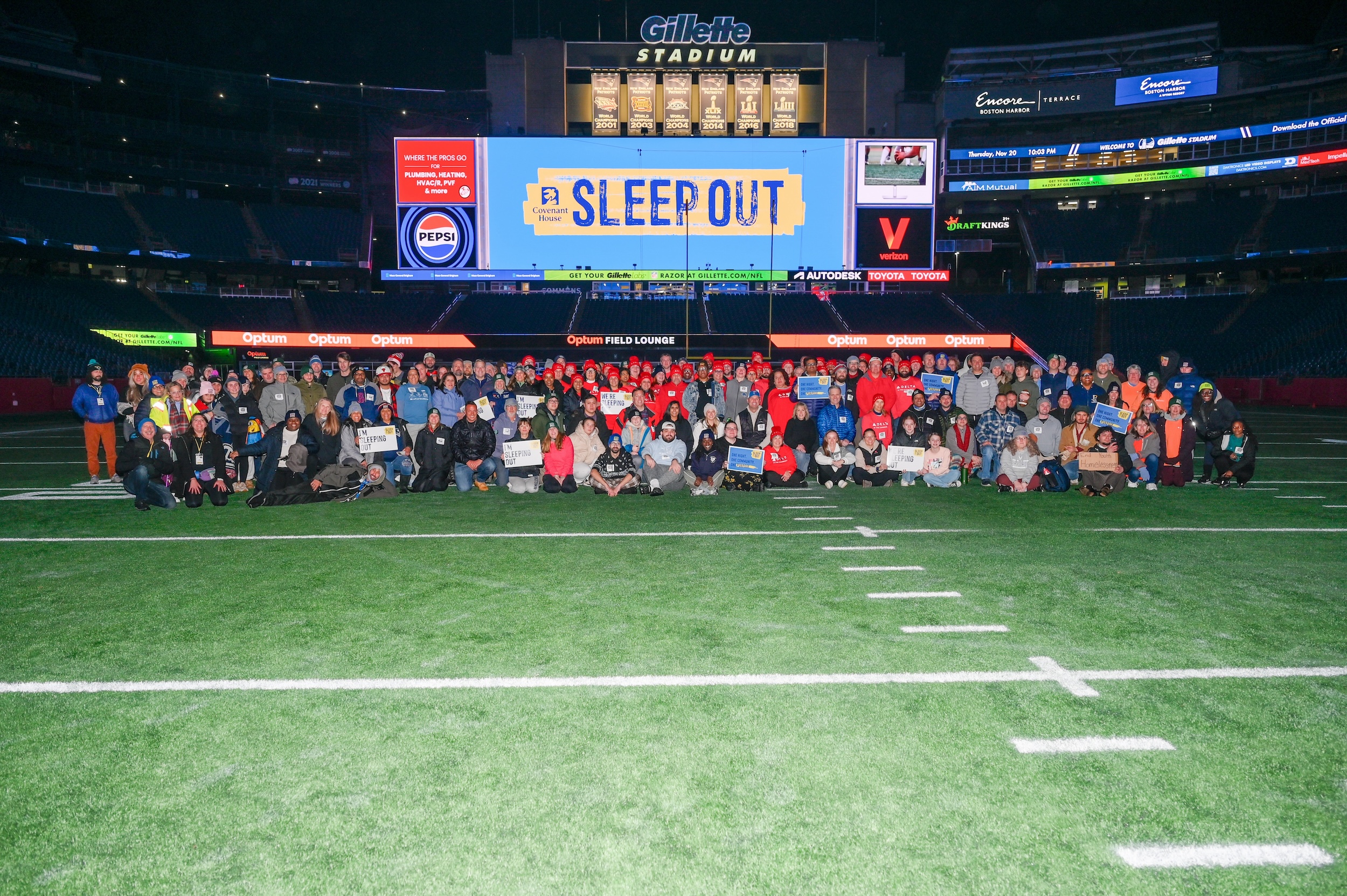 t Gillette Stadium in Foxborough, MA, 2025 Sleep Out participants pose on the field and under the scoreboard before sleeping out.