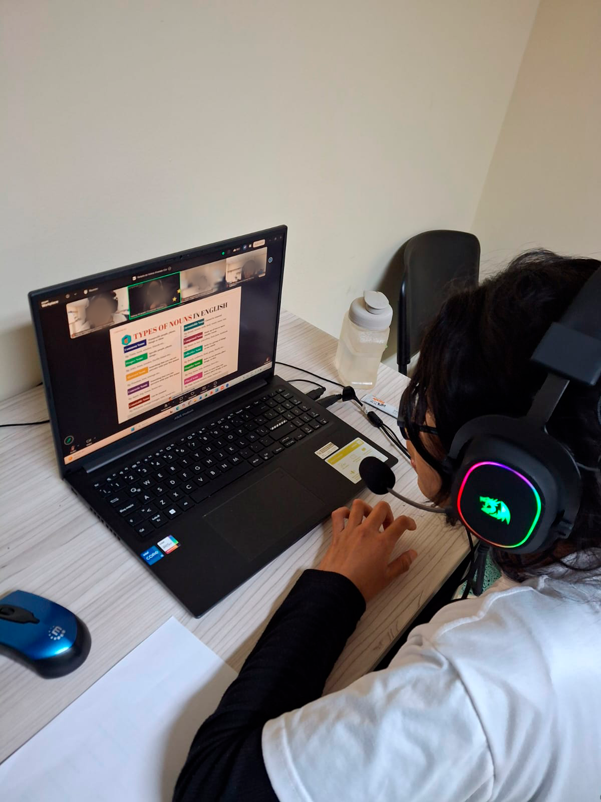 Lucy sits in front of her computer with headphones on, participating in an online class at Covenant House Guatemala.