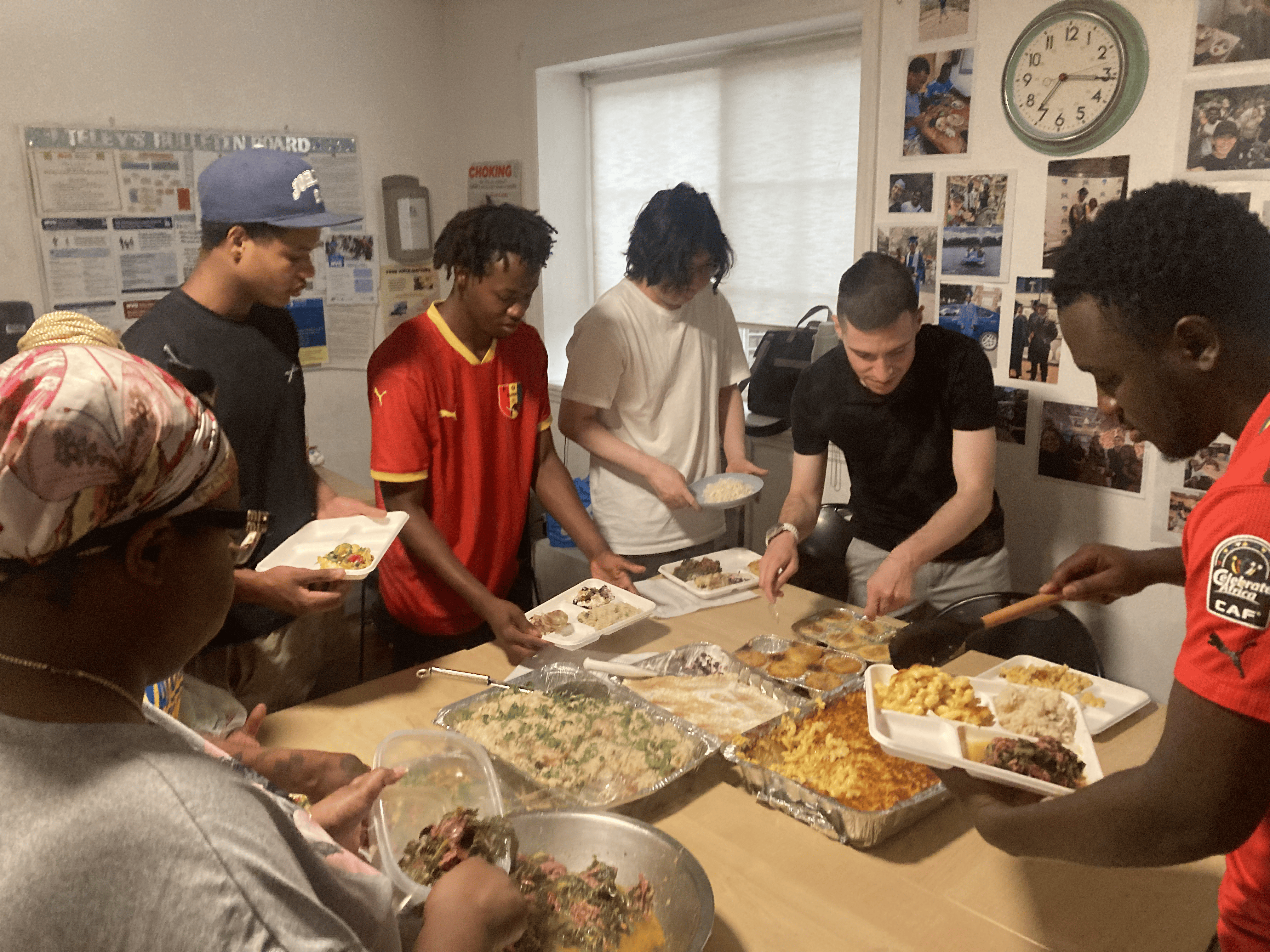 A group of Covenant House residents congregate over the food they all cooked from recipes sent to them by supporters.
