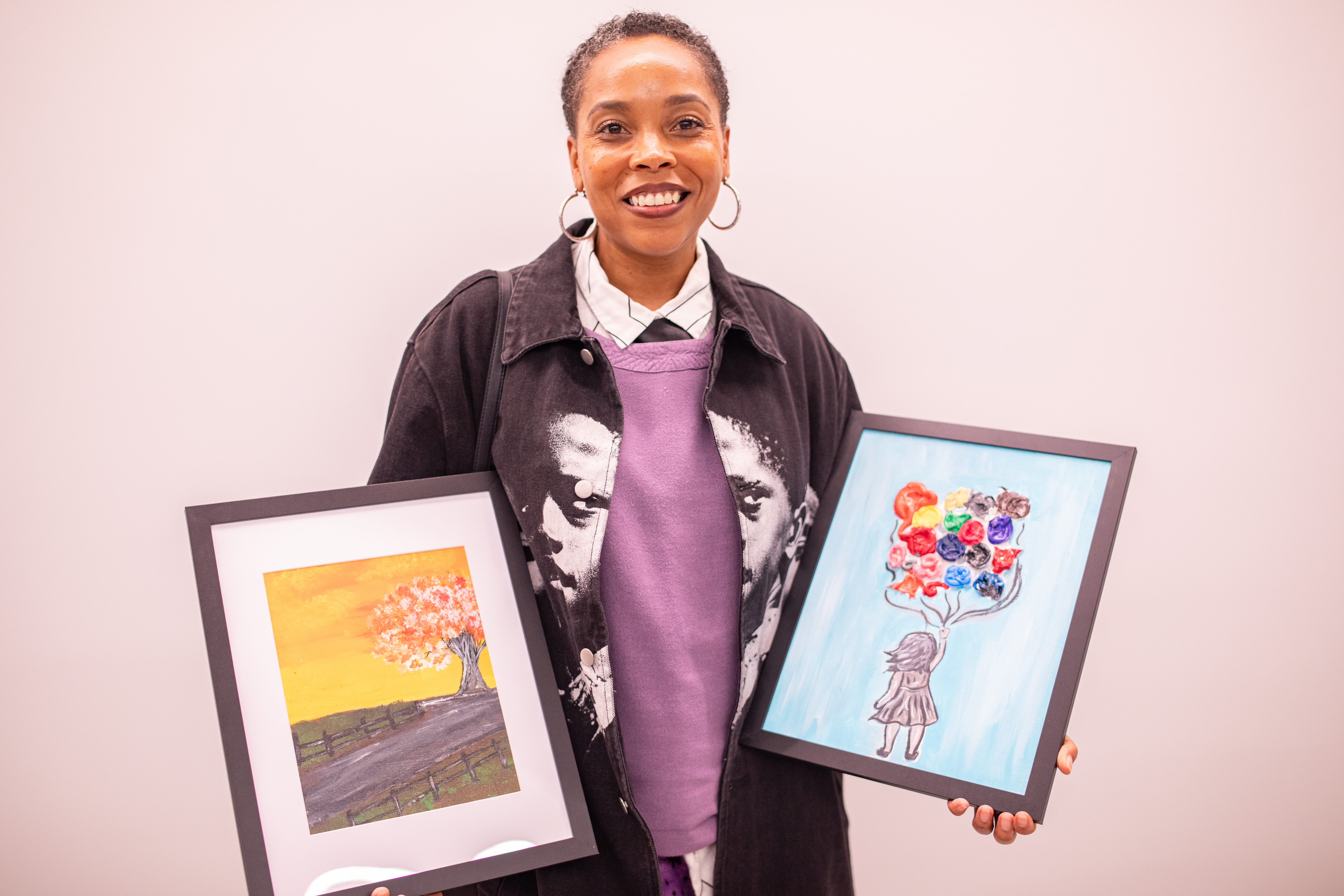 A CHNY Youth Art Show patron shows two works she purchased.