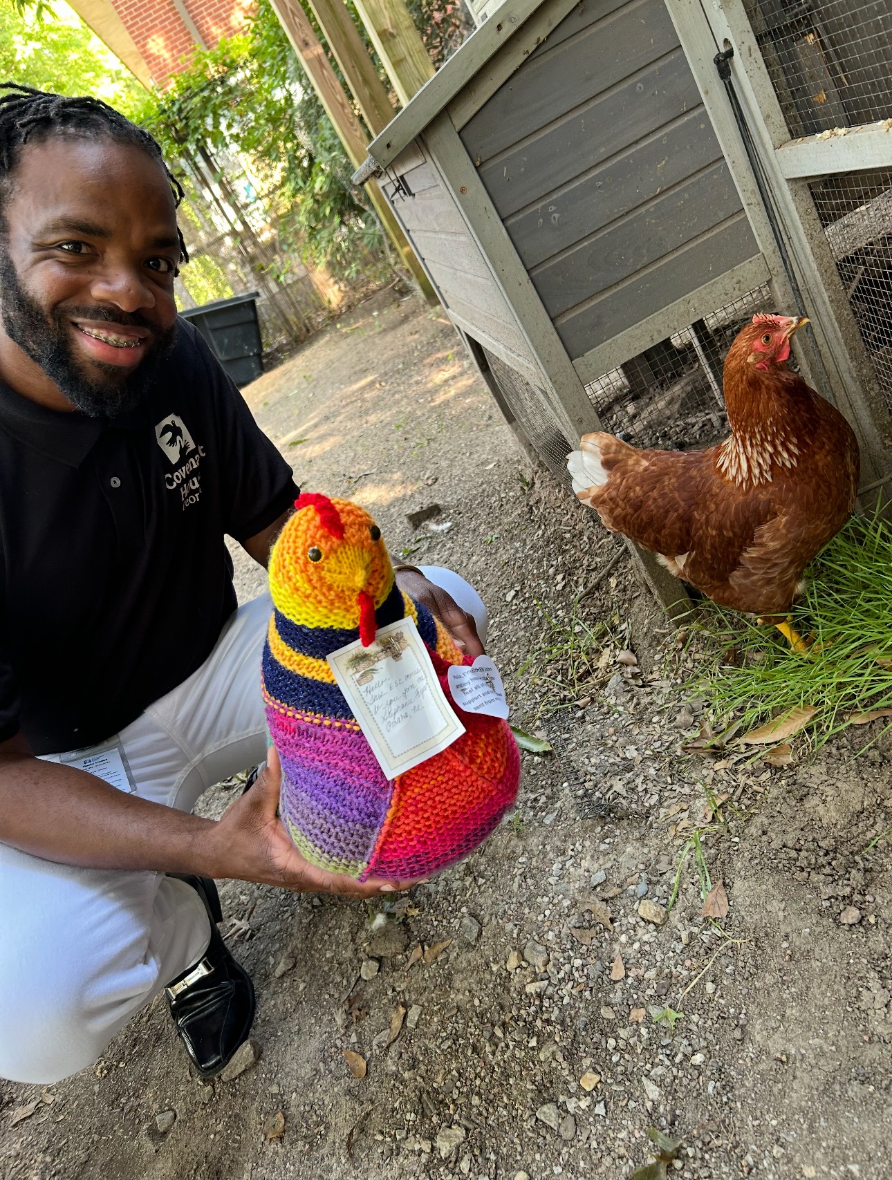 Covenant House Georgia staff member showing off his hand-knit emotional support chicken next to an actual live chicken.