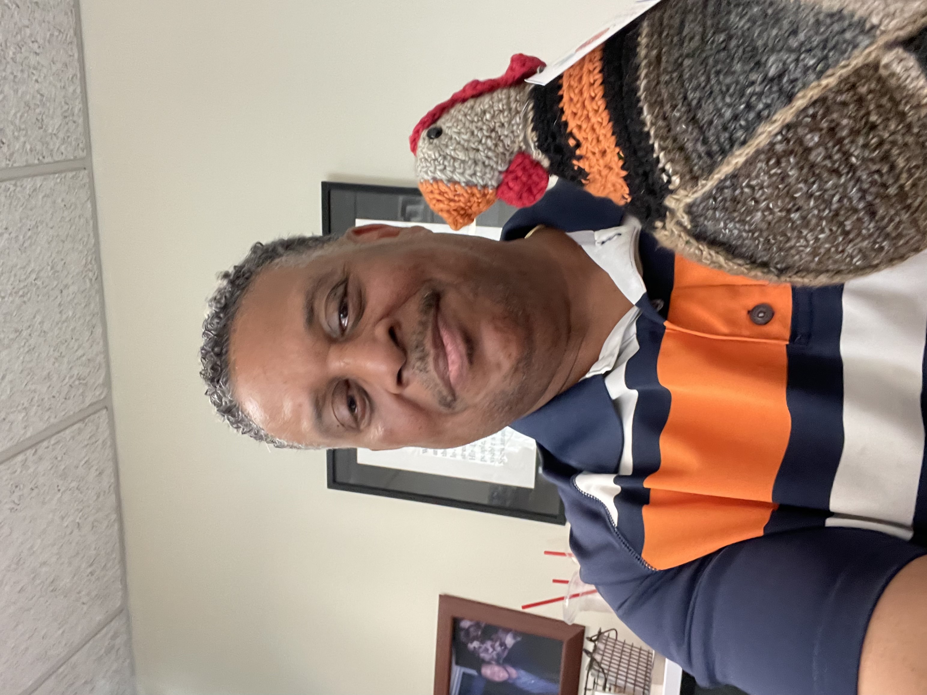 A gentlemen showing off the hand-knit emotional support chicken at a Covenant House location.