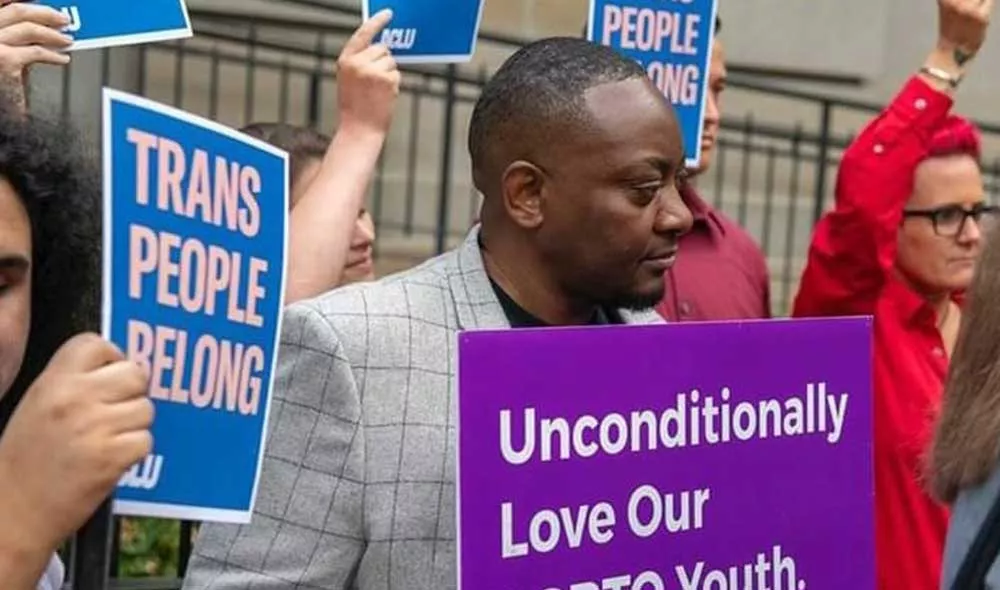 Covenant House alumni Iden protesting with sign