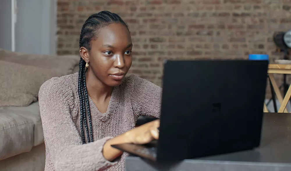 Former homeless young woman using laptop