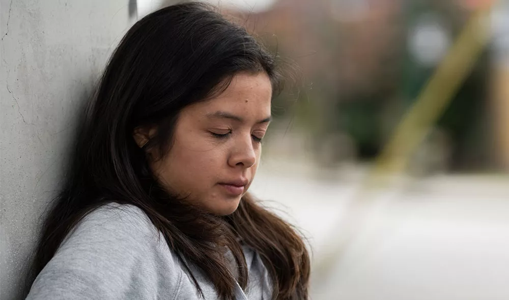 Human trafficking survivor leaning against wall | Covenant House