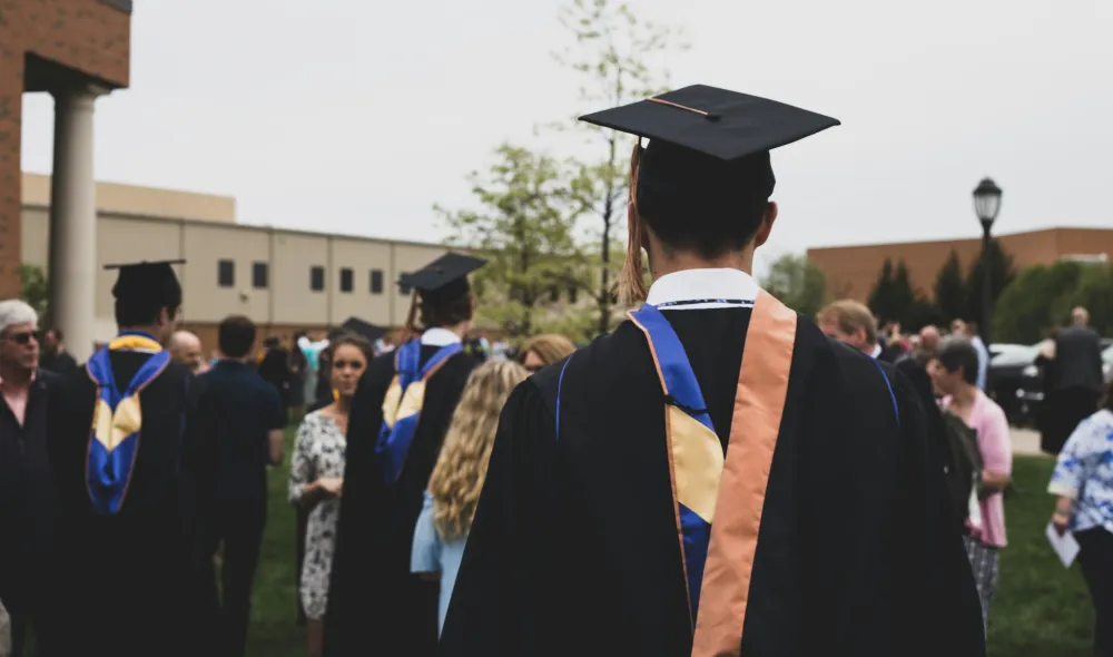 Covenant House alumni walking at a college graduation.