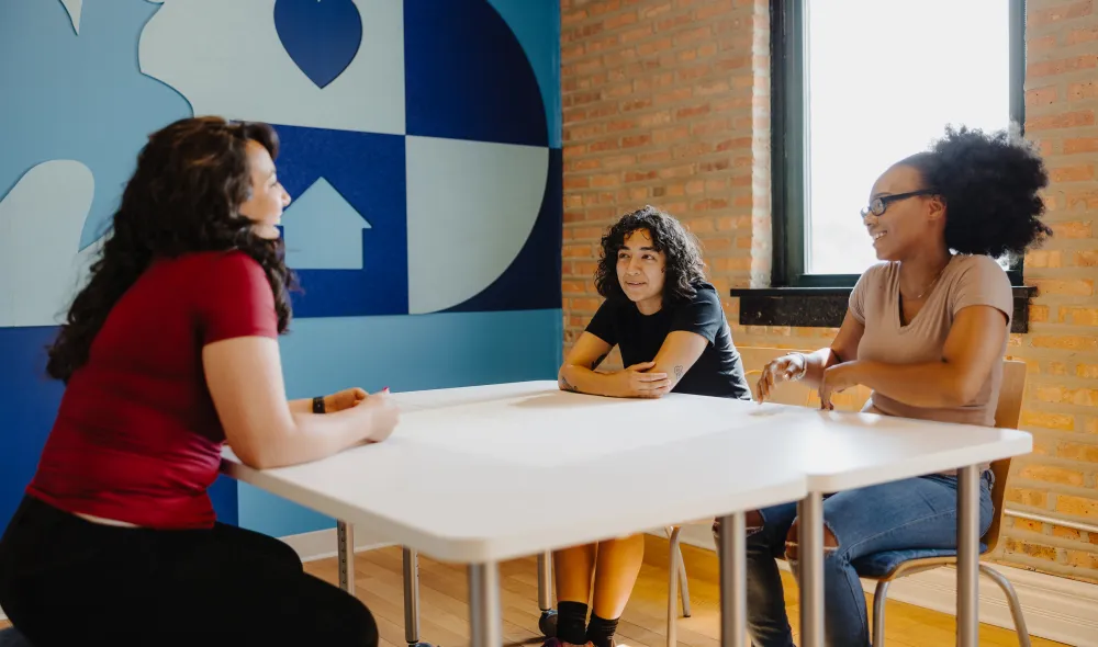 A counselor meeting with two young residents at Covenant House Chicago.