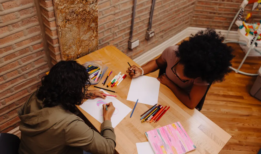 Two residents at Covenant House in Chicago work on art projects together.
