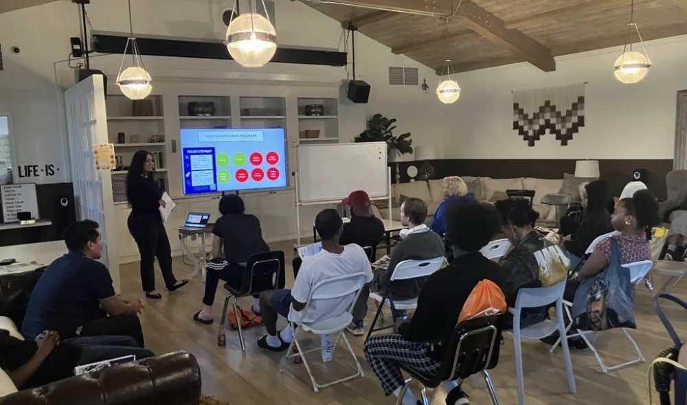 Covenant House California employee walking residents through an educational support slide show and presentation.