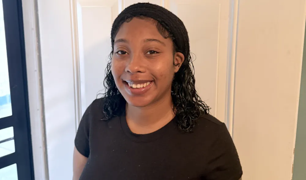 Jahan, a resident of Covenant House New Orleans, stands proudly as she completes her GED and plans for a better future for herself and her baby.