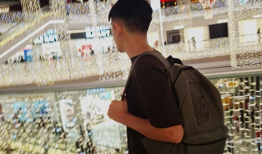 Felipe walks among the glitter of lights at a chopping mall.