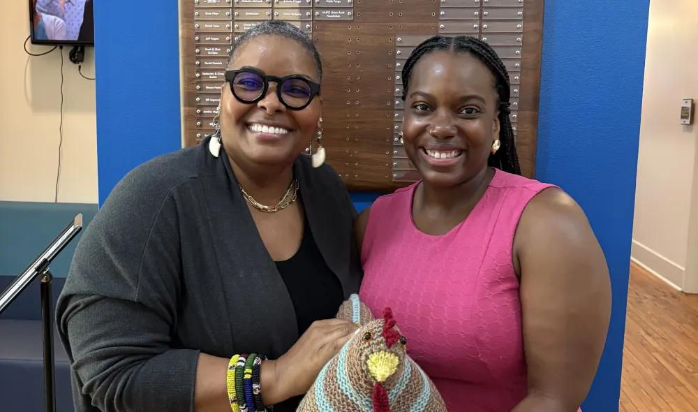 Regina Jennings and a Covenant House Georgia staff member show off a hand-knit emotional support chicken.