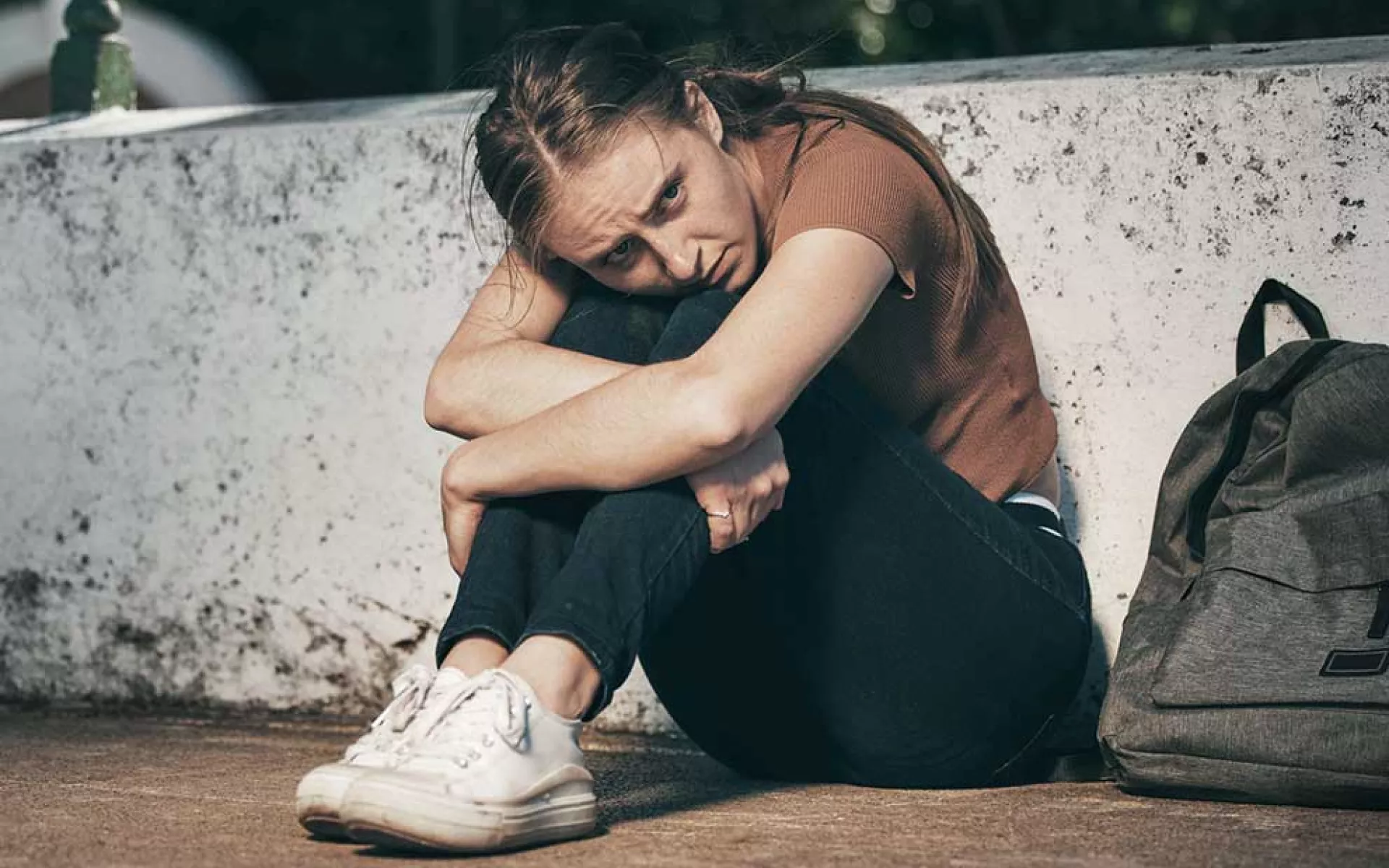Homeless youth sitting on pavement | Covenant House