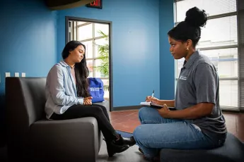 Young woman talking to a Covenant House staff member
