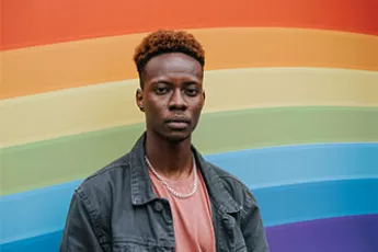gay teen in front of rainbow wall | Covenant House