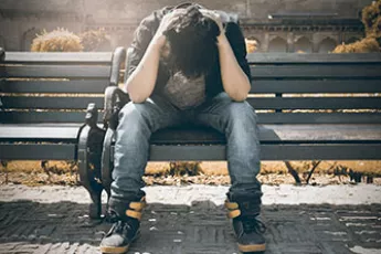 stressed homeless kid on bench | Covenant House - Gaps in Foster Care