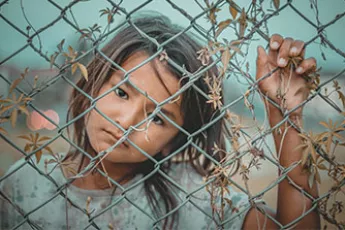 trafficked girl behind fence | Covenant House - Know the Issues - Human Trafficking