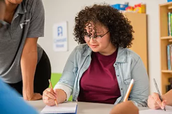 former homeless kid doing schoolwork at Covenant House | Youth Homeless Awareness Month