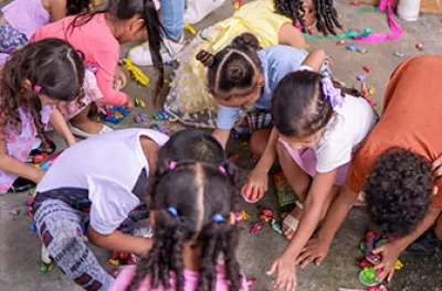 former homeless Latin American children picking up candy from piñata | Covenant House - Latin America