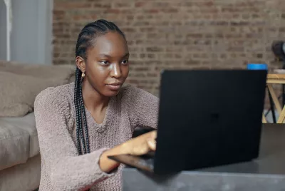 Former homeless young woman using laptop
