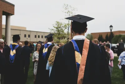 Covenant House alumni walking at a college graduation.