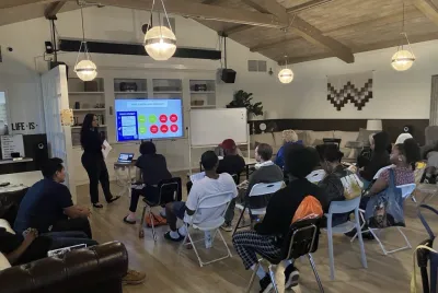 Covenant House California employee walking residents through an educational support slide show and presentation.