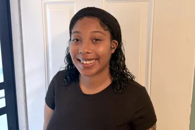 Jahan, a resident of Covenant House New Orleans, stands proudly as she completes her GED and plans for a better future for herself and her baby.