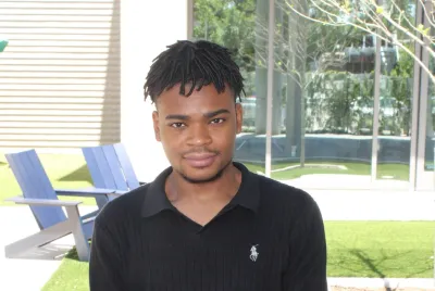 Prince from Covenant House Texas poses outside in a courtyard.