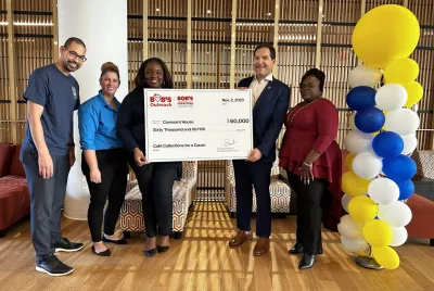 Executive for Bob's Furniture hands a large $60,000 check to members of Covenant House.