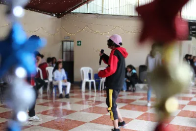 Covenant House Guatemala resident Lucy hold microphone and performs for her peers.