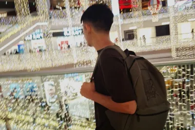 Felipe walks among the glitter of lights at a chopping mall.