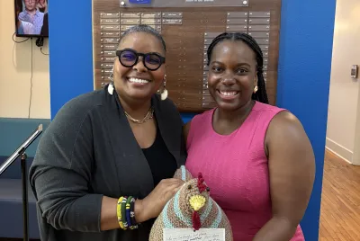 Regina Jennings and a Covenant House Georgia staff member show off a hand-knit emotional support chicken.