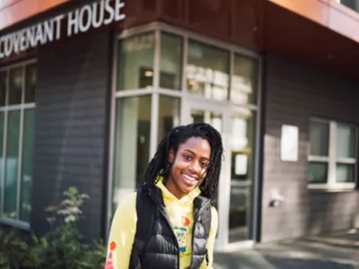 Smiling youth in front of Covenant House building