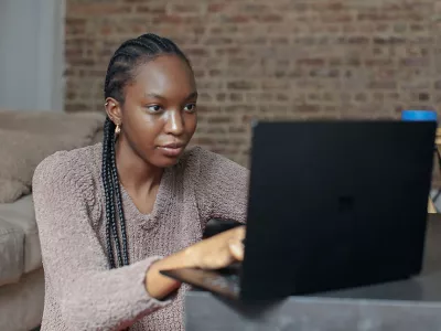 Former homeless young woman using laptop