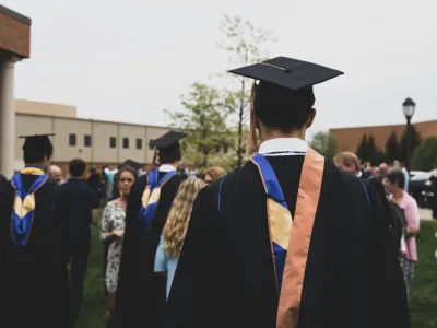 Covenant House alumni walking at a college graduation.