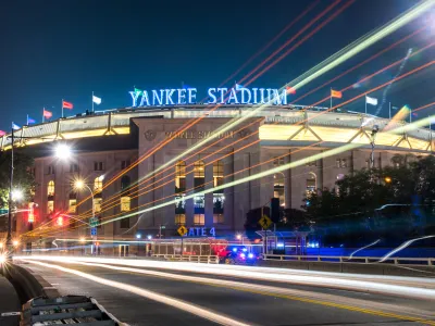 A nighttime, time-lapse, wide-shot photo of Yankee Stadium.