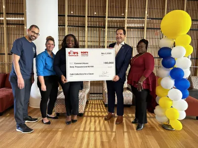 Executive for Bob's Furniture hands a large $60,000 check to members of Covenant House.
