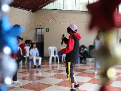 Covenant House Guatemala resident Lucy hold microphone and performs for her peers.