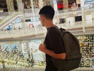 Felipe walks among the glitter of lights at a chopping mall.