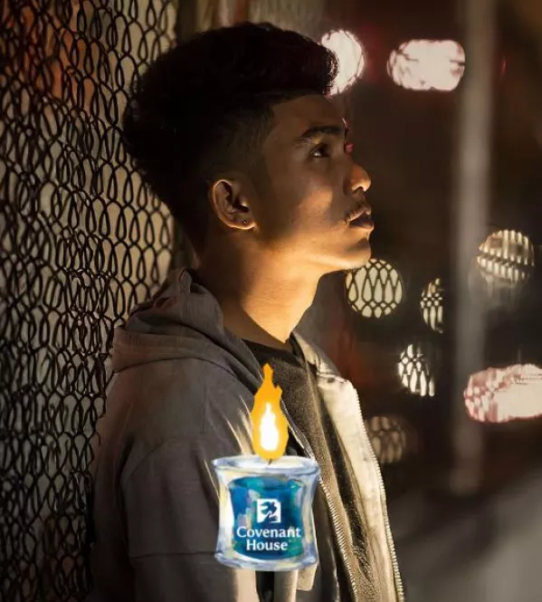 young homeless teen leaning on fence with vigil candle | Join our candle vigil to support homeless kids
