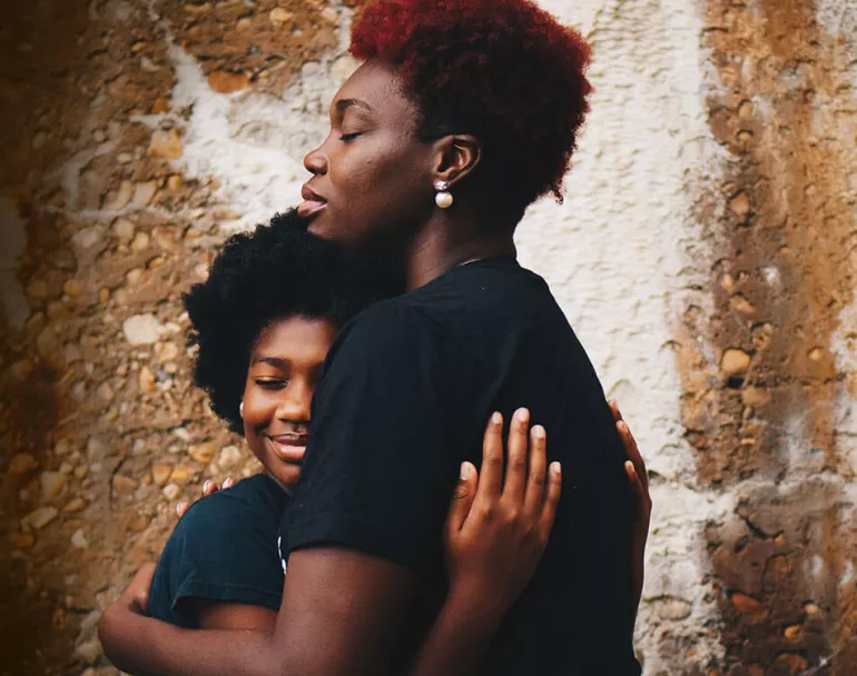 Young mother facing homelessness hugging her daughter