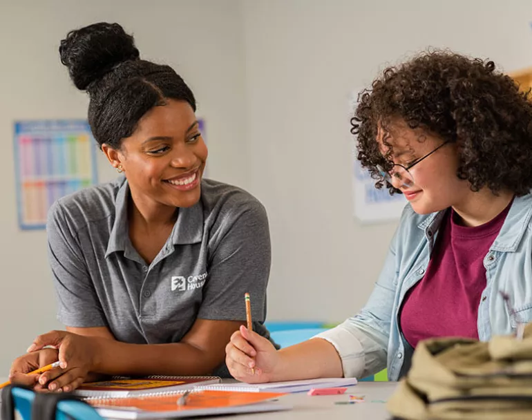 Covenant House staff talking to a young lady at a table